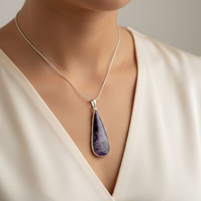 necklace with a purple teardrop pendant against a neutral background