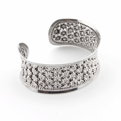 Silver open cuff bracelet with embedded stones on a white background